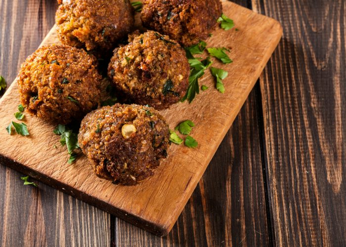 hemp seed falafel balls sprinkled with parsley served on a wooden board