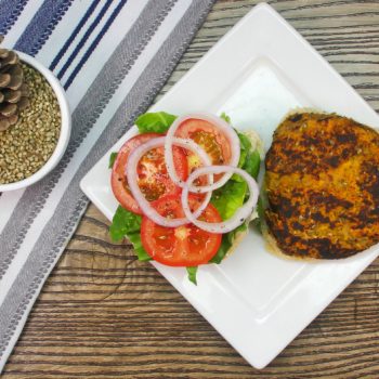 Hemp seed burger patty and vegetables on a white plate