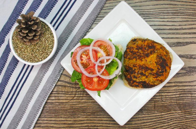Hemp seed burger patty and vegetables on a white plate