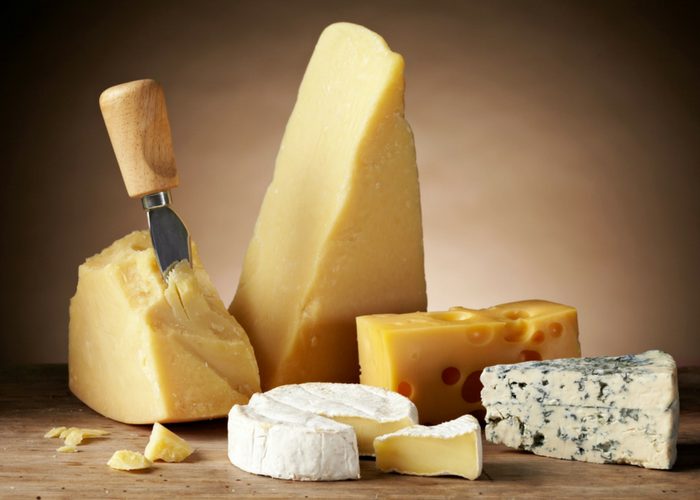 different types of cheeses such as brie, Parmesan, cheddar, and blue cheese on a table