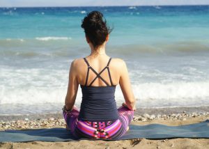 woman on the beach following the meditation tip to meditate with a straight back