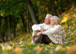 a couple with white hair sitting in a field