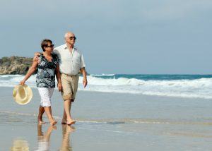 elderly couple enjoying a stroll on a beach