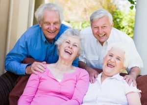 a group of elderly people laughing together as positivity is a secret to living to 100