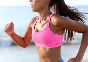 woman running in a bright pink sports bra