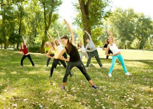 group of women doing stretching exercises outdoors and getting a workout without the gym