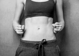 black and white photo of a woman's toned abs