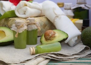avocado oil and fresh avocados surrounded by other spa essentials
