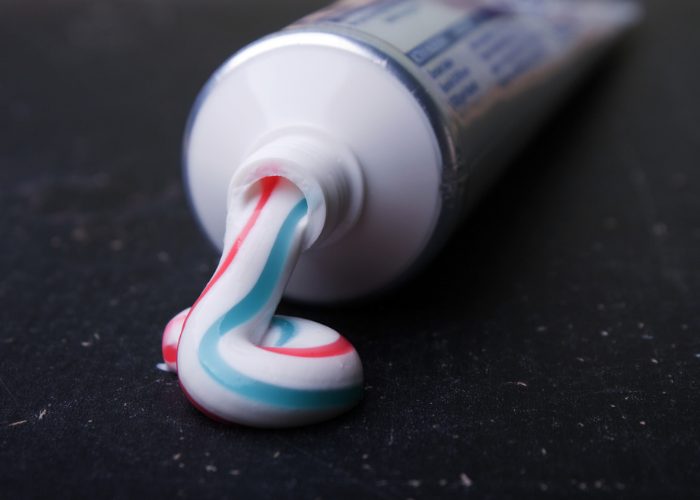 tube of toothpaste being used as a DIY life hack to patch up walls