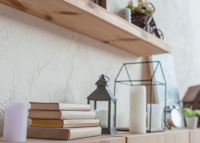 a DIY wall shelf with candles and books on it