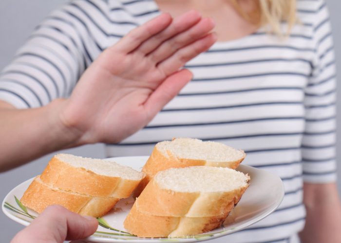 woman with food intolerance to gluten declining white bread