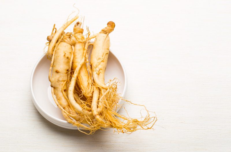 Top down shot of ginseng roots on a white dish