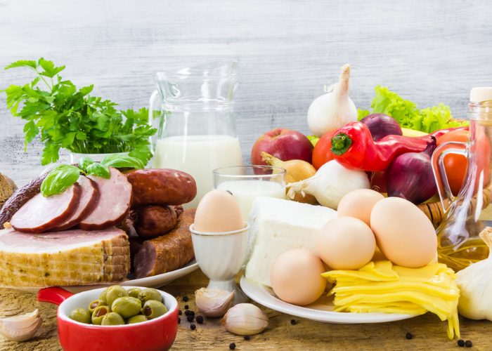 a spread of high protein meat and dairy food products like eggs, milk, and meat laid out on a table