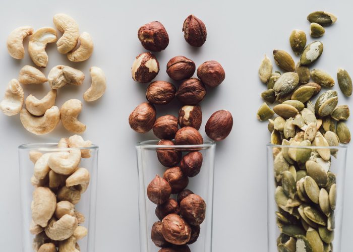 protein rich cashews, pistachios and macadamia nuts lined up on a table