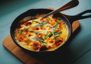 one pot meal of baked potatoes topped with cheese in a skillet