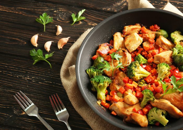 Stir fried chicken, broccoli and peppers in a skillet