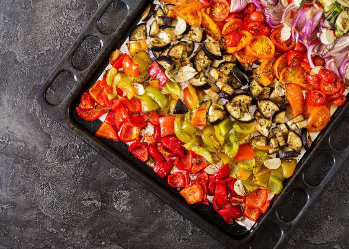 one pot meal of roasted peppers, eggplant, tomatoes, onions, and zucchini on an oven tray