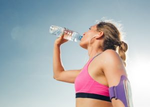 woman drinking water after her run