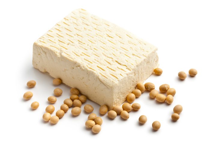 a block of tofu and soy beans on a white table