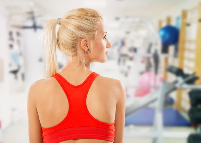 Blonde woman wearing red sports bra in the gym
