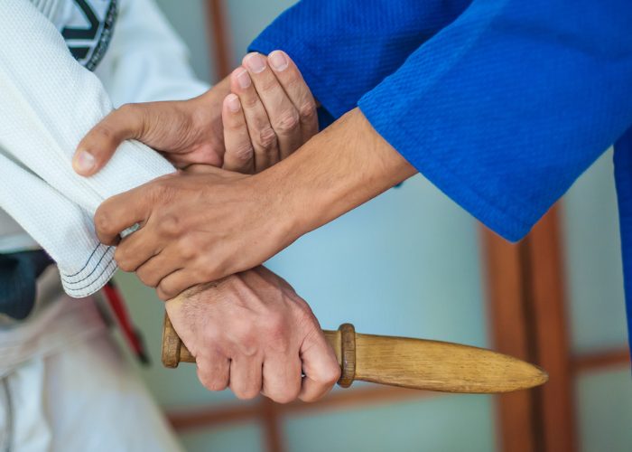 Coach demonstrating a defensive kali martial arts move against an opponent with a knife