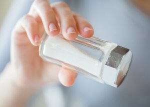 Woman pouring salt out from a salt shaker