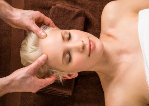 Woman looking relaxed getting a head massage at a spa