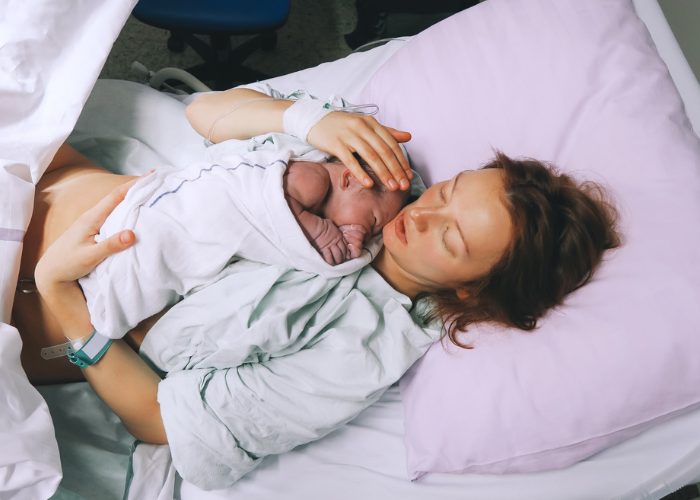 Woman holding her newborn after just giving birth