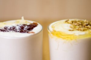 Two glasses of homemade coconut yogurt with different toppings