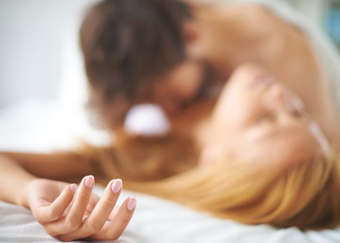 A defocused shot of a couple in bed having sex