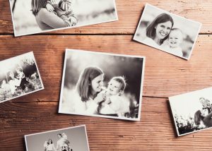 Black and white photographs of a mother and her baby laid out on a wooden floor