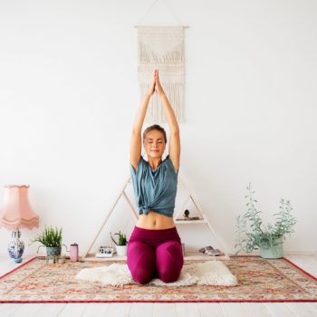 Woman practicing Kundalini yoga at home