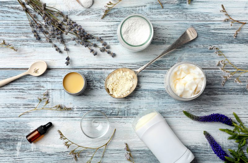 Ingredients for natural deodorant laid out neatly on a grey table