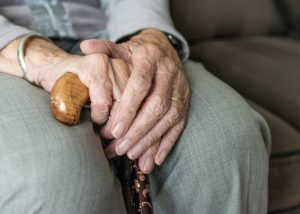 Close up of an old woman's hands holding onto her cane
