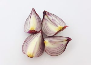 Four quarters of a prebiotic-rich onion on a white surface