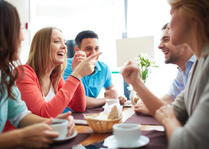 Young woman chatting and laughing with friends at a cafe