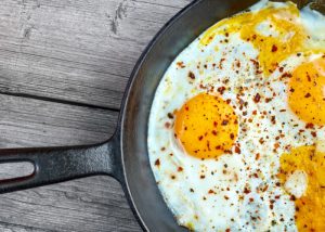 A pan of fried eggs topped with paprika
