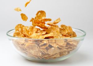 Corn flakes cereal in a clear glass bowl