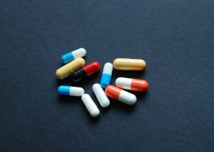 A scattering of colorful pills on a dark blue background