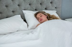 Blonde woman sleeping soundly under her weighted blanket