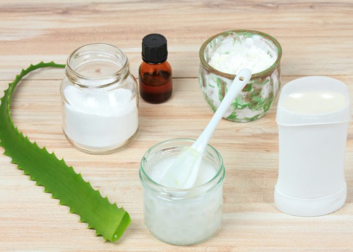 Ingredients for natural homemade deodorant in jars and a fresh aloe vera leaf on a wooden table