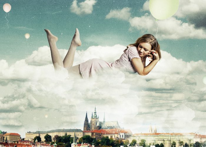 Woman in a dream floating on a cloud above a city