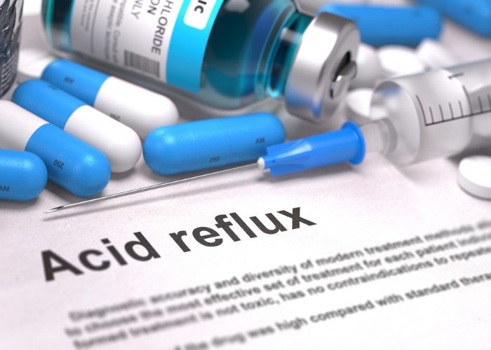 Medicines on a document with large "acid reflux" text