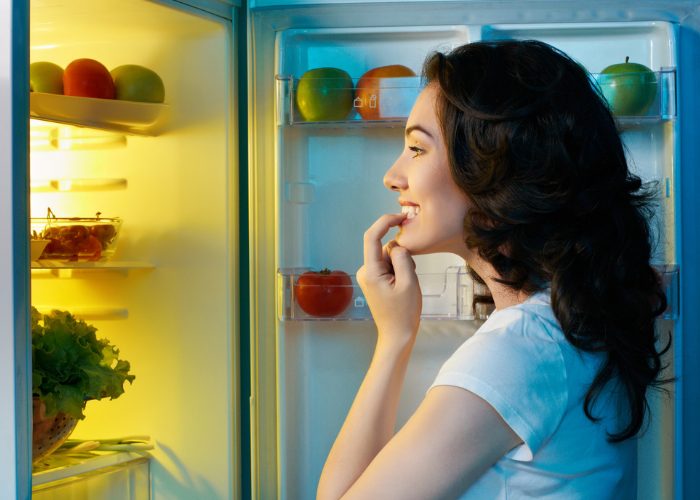 Woman looking into her fridge for food late at night