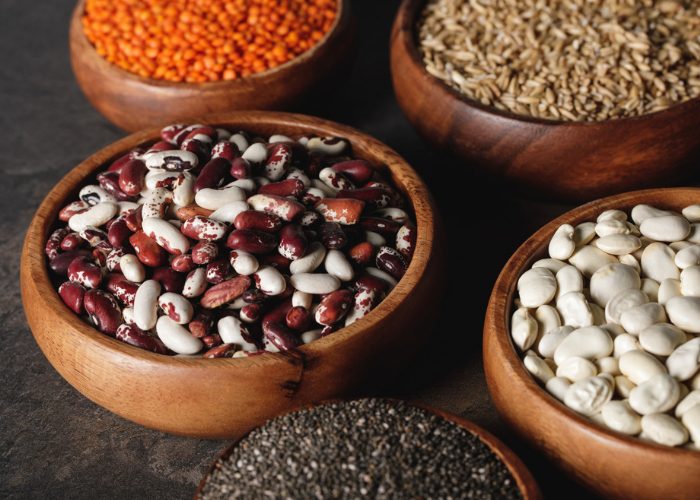 Different beans, lentils and other plant proteins in wooden bowls