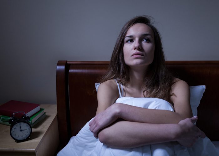 Woman with insomnia sat up in bed at night