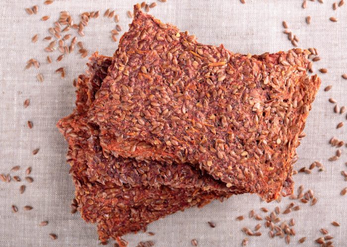 Pieces of stacked healthy fiber crispbreads with seeds sprinkled around it