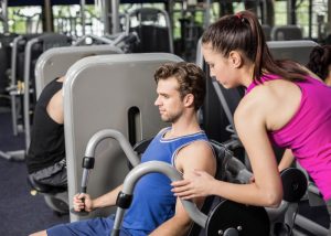 Personal trainer coaching a male client at the gym