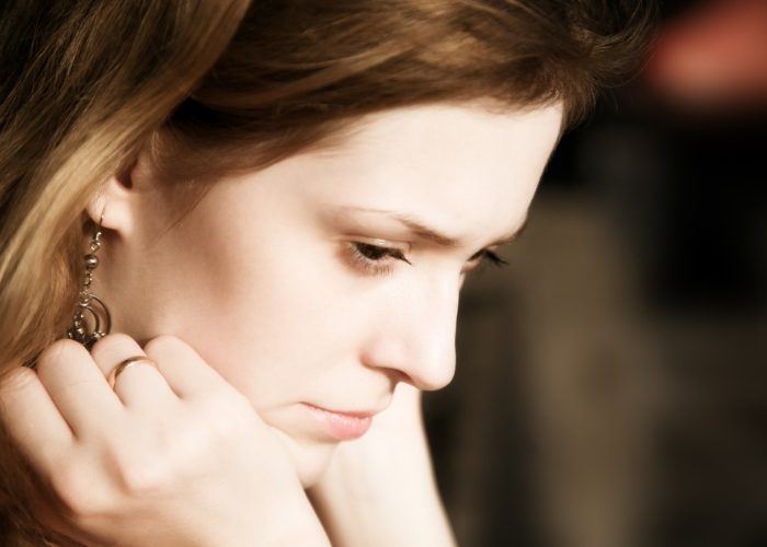 Close up of sad looking woman staring down at the ground