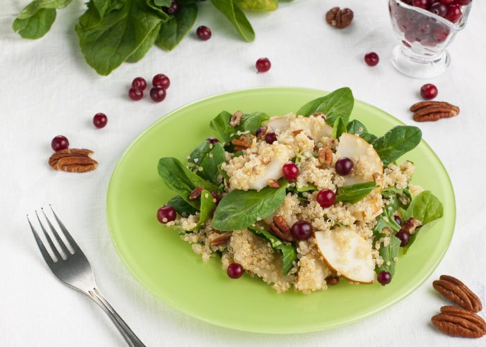 A plate of quinoa and cranberry salad on a white table